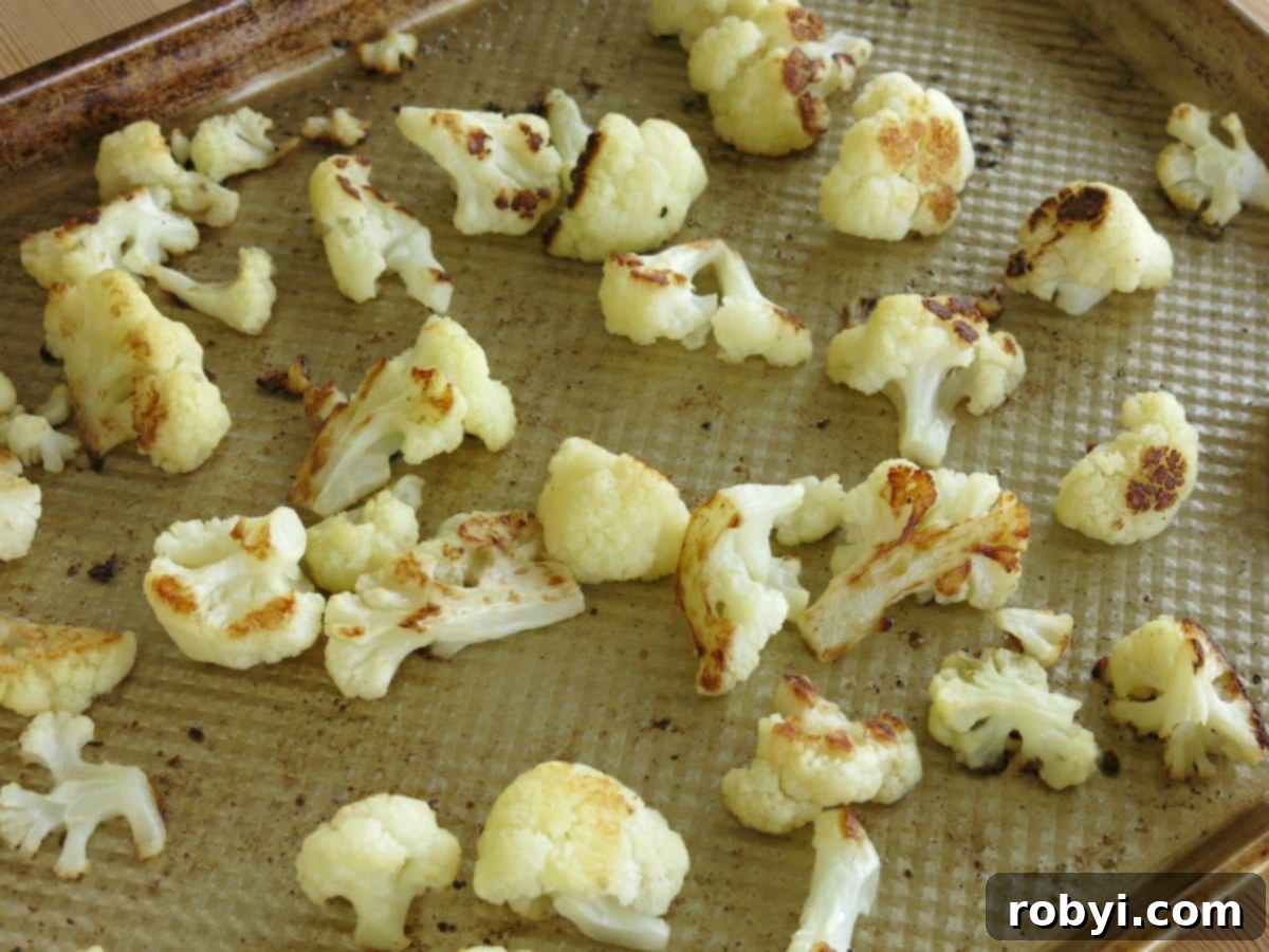 Roasted cauliflower florets on a sheet pan.