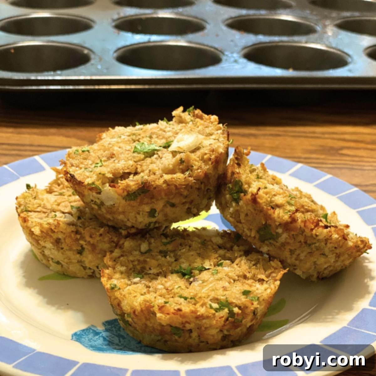 Baked Salmon Cakes: Two Ways (Patties or Muffin Tin) 4 A vibrant plate featuring salmon patties cooked in a muffin tin, showcasing their perfectly rounded shape and golden crust, with a muffin tin blurred in the background.