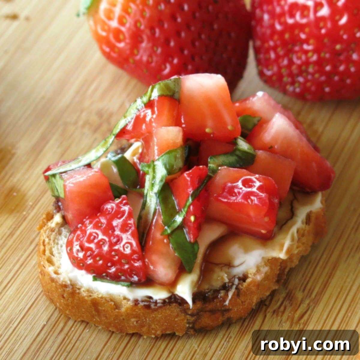 Strawberry Bruschetta with cream cheese, basil and balsamic vinegar reduction on thin slice of baguette.