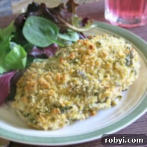 Parmesan Herb-Crusted Chicken on a plate with salad greens.