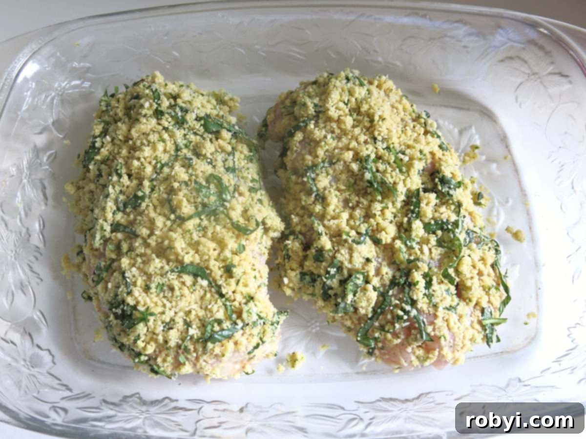 Uncooked Parmesan Herb Crusted Chicken breasts arranged in a baking dish, ready for the oven.