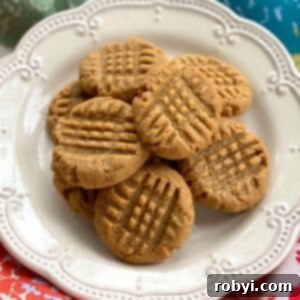 3-ingredient almond butter cookies on a cream plate.