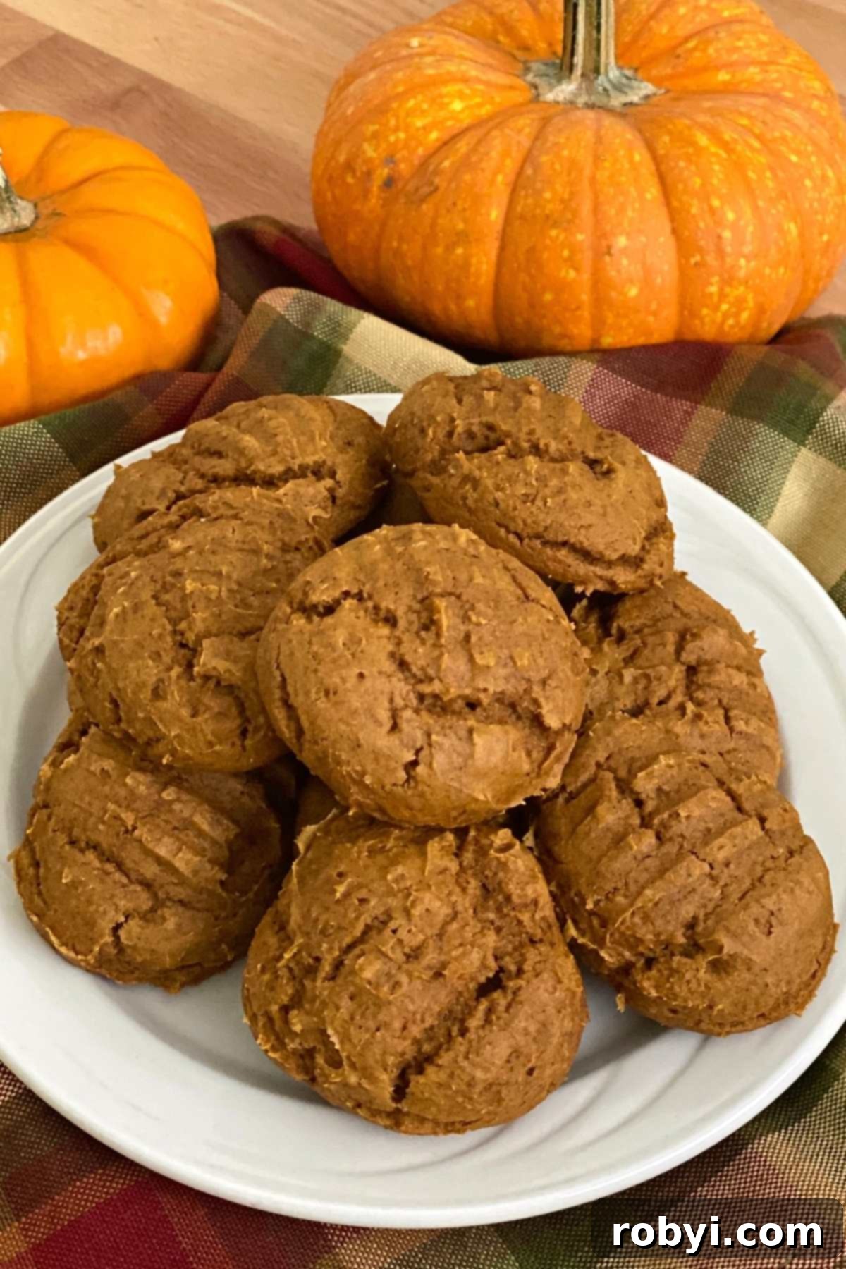 Plate of delicious 2-ingredient pumpkin cookies made with cake mix, featuring decorative pumpkins in the background.