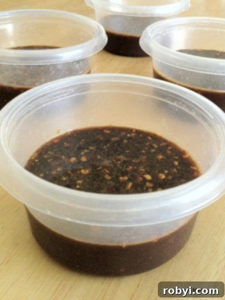 Four small containers filled with Molasses Marinade, ready for freezing with pork chops.