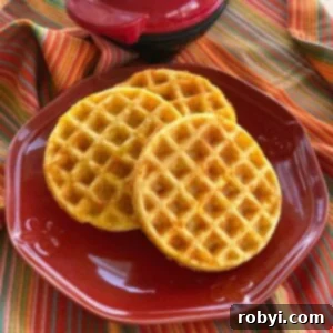 Keto chaffles on plate with Dash mini waffle maker behind it.