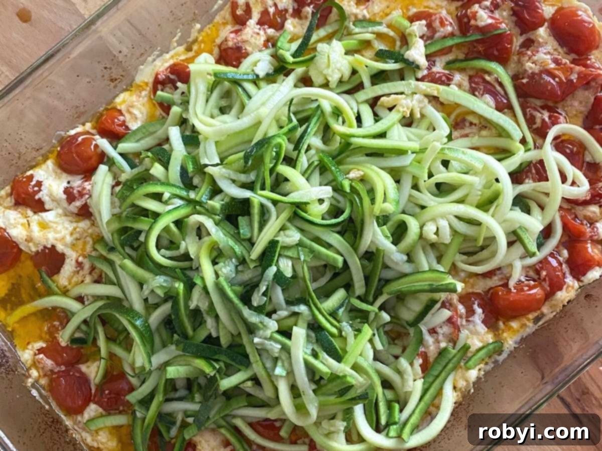 Creamy Baked Feta Shrimp with Zucchini Noodles 4 Spiralized Zucchini on top of cooked feta and tomatoes.