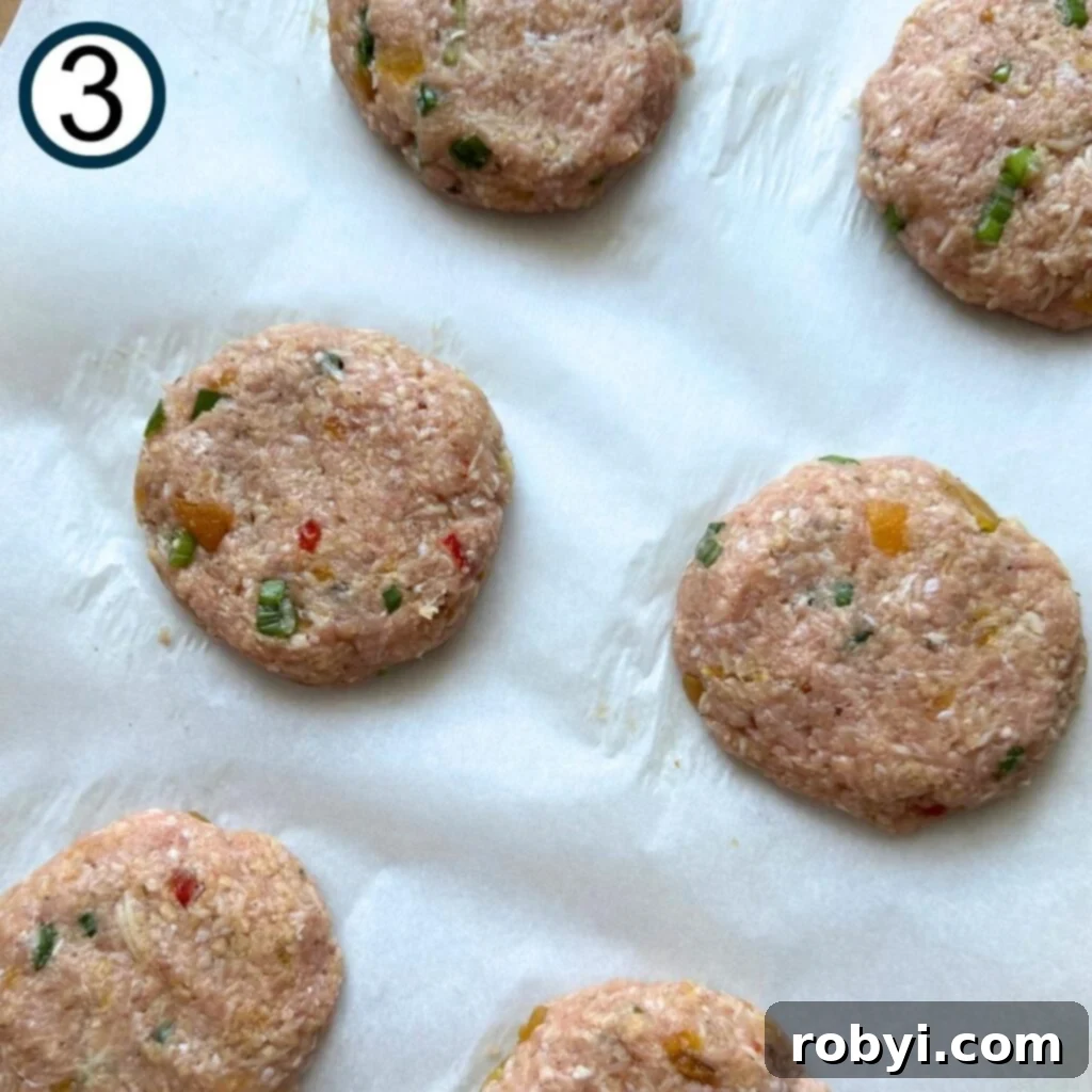 Six mango chutney turkey burger patties on parchment paper.