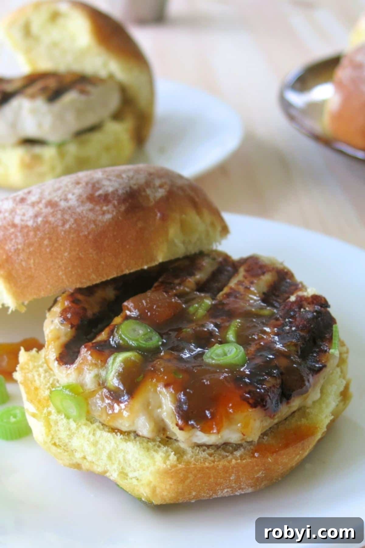 Grilled turkey burger with mango chutney on a bun with top off center.