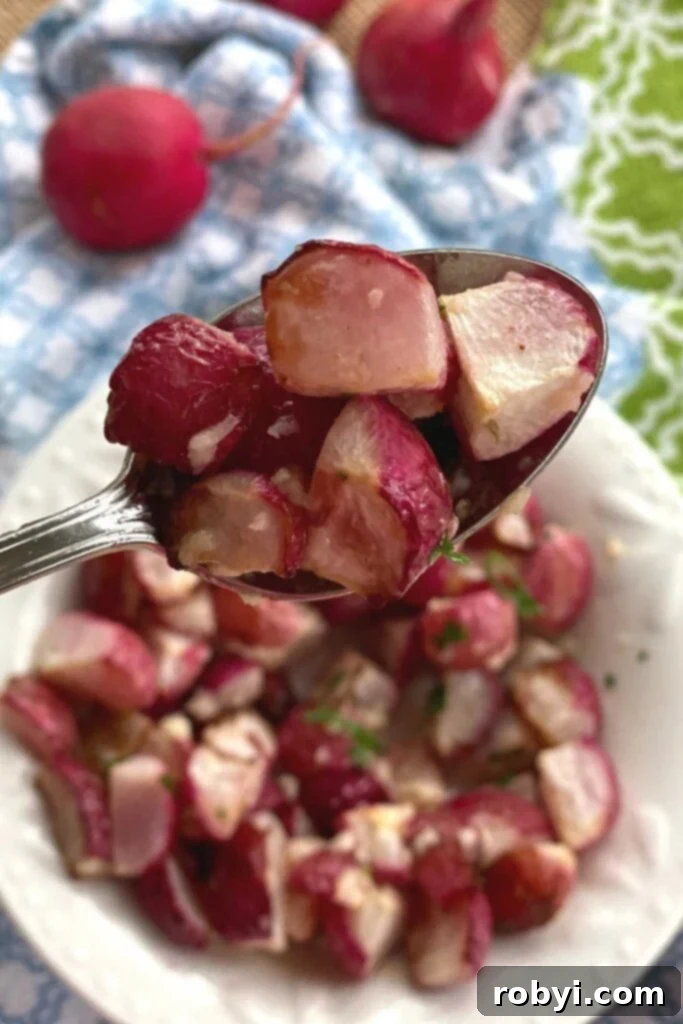 Roasted radishes being lifted out of a bowl on a spoon.