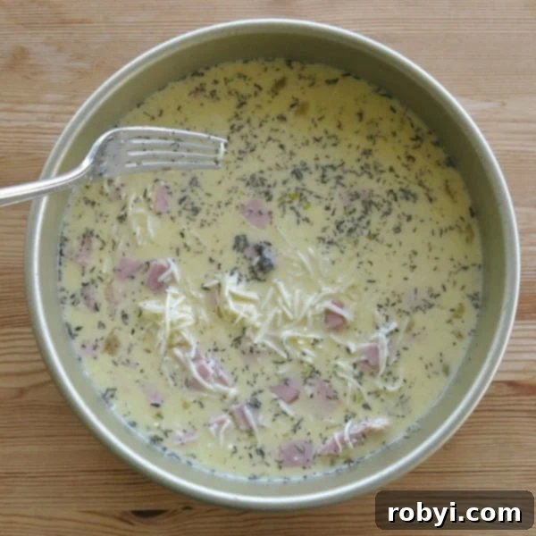 Smart Prep Crustless Quiche Freeze For Later 3 Crustless quiche filling in pan with fork to distribute ingredients.