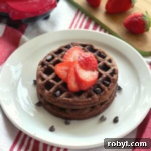 Decadent Chocolate Chaffles with Ricotta 6 Two Chocolate chaffles on a plate topped with strawberries.