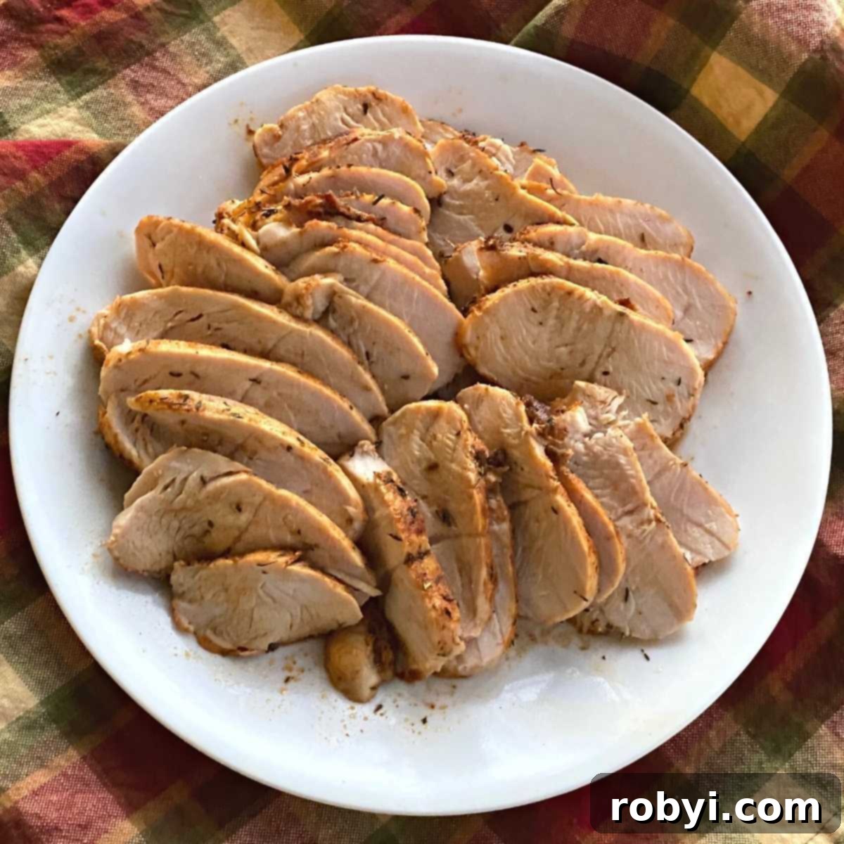 Perfectly sliced, moist turkey breast tenderloin arranged beautifully on a plate, showcasing its tender texture.