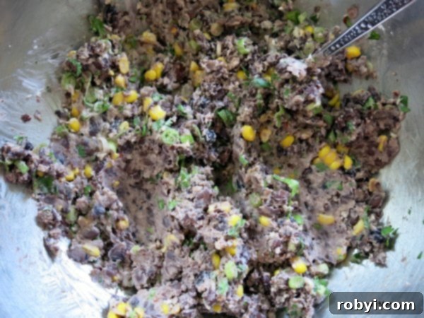 A colorful mixture of black beans, corn, and spices ready to be formed into patties