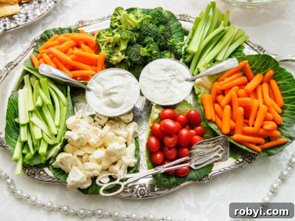 Platter of assorted cut vegetables around cups of dip.