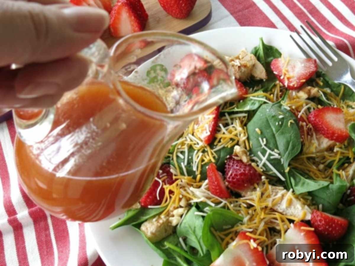 Sweet red wine vinegar dressing being poured over a green salad.