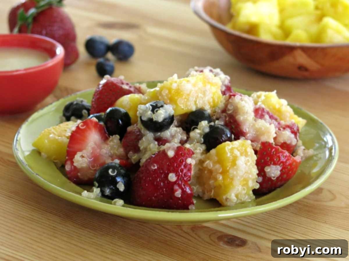 Quinoa fruit salad with strawberries, blueberries, and pineapple on a plate.