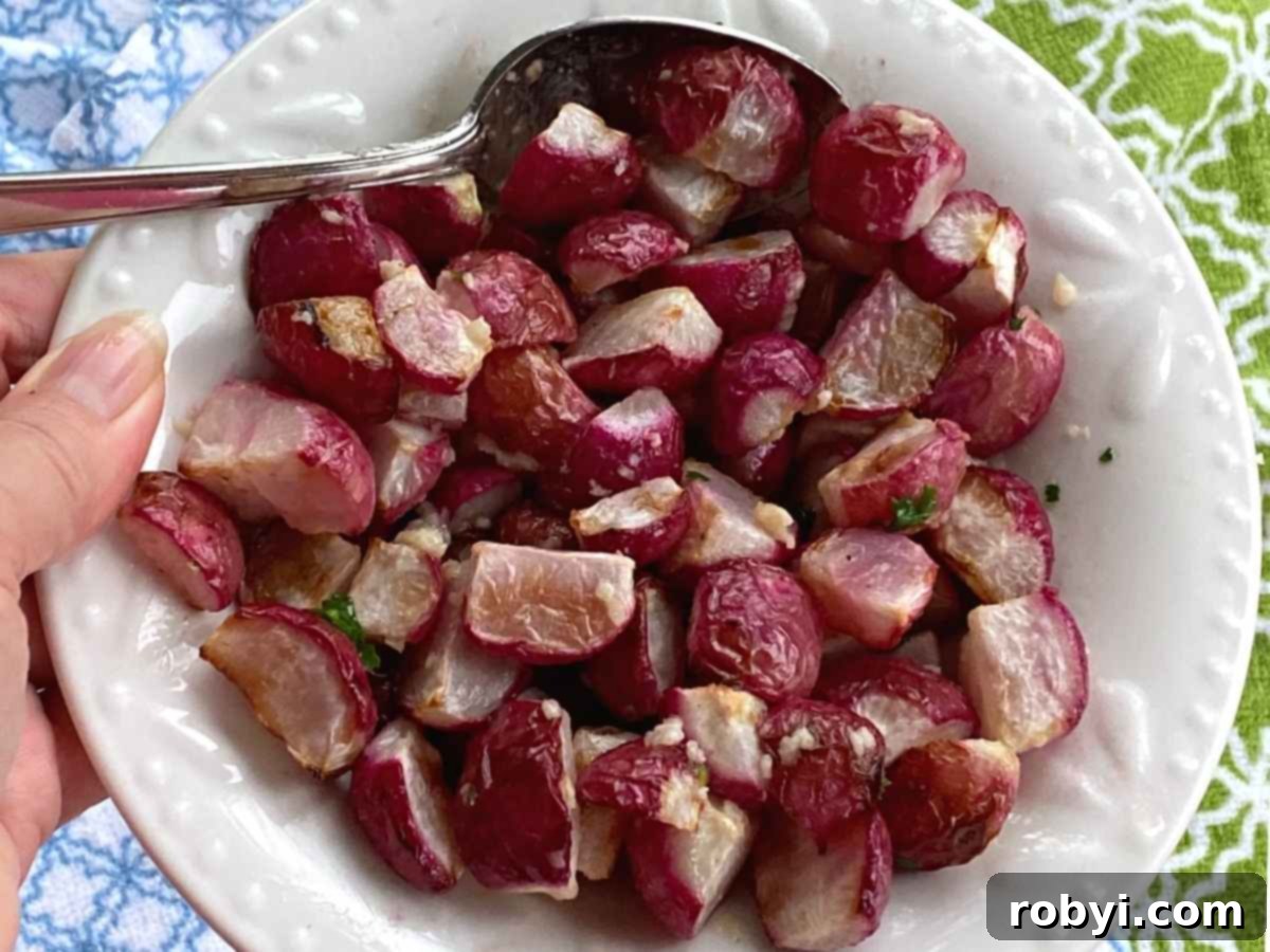 Hand holding bowl with roasted radishes.