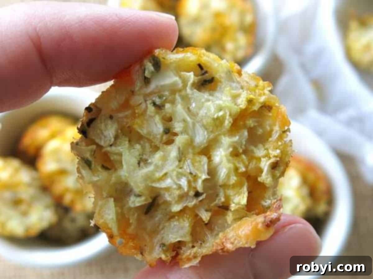 Finger holding a cauliflower tot.