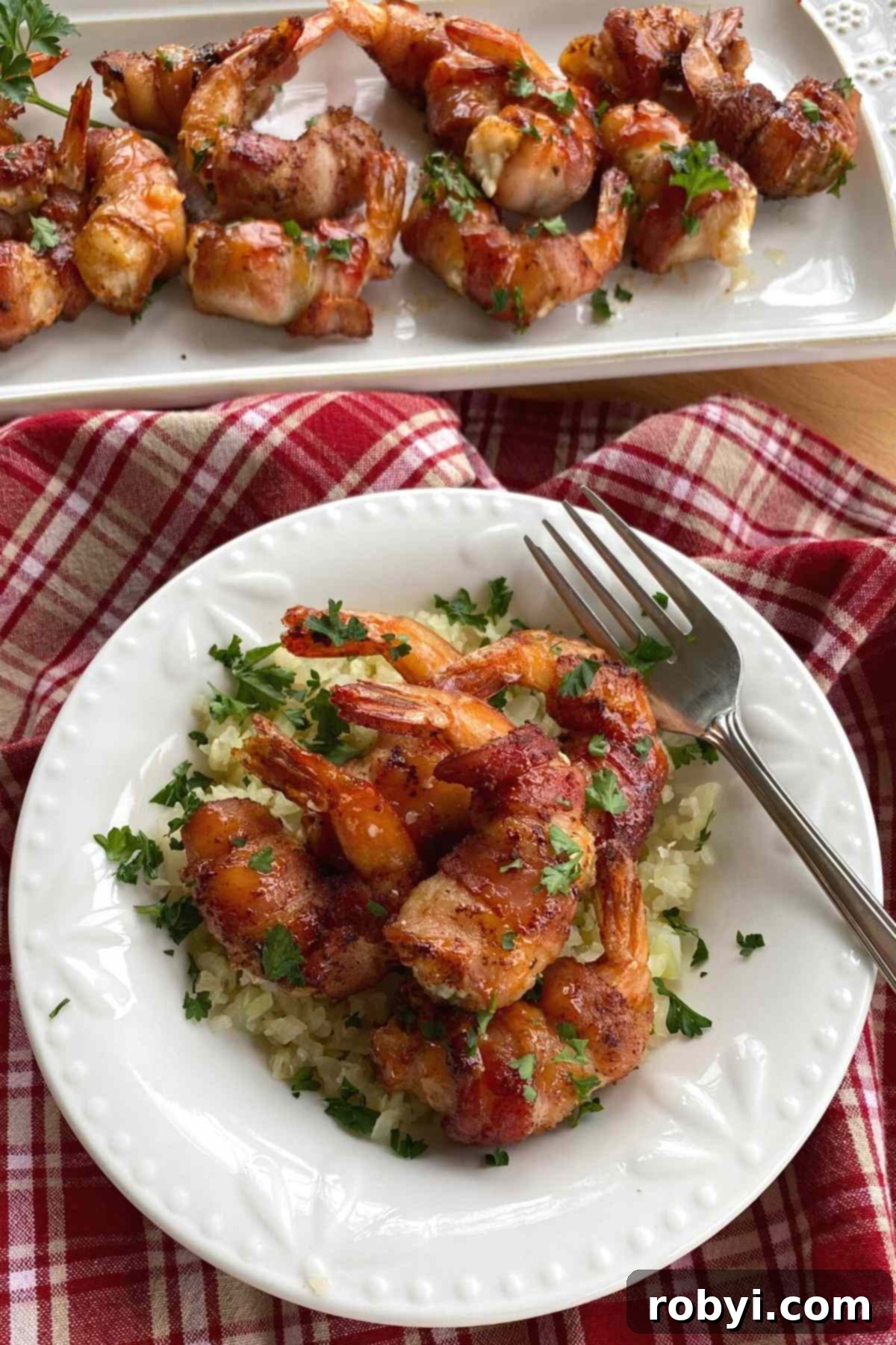 Voodoo Shrimp, artfully arranged over creamy cauliflower grits, showcasing a gourmet main dish presentation.