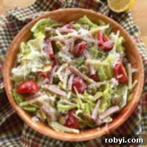 Columbia 1905 Salad with ham, cheese, green olives, and tomatoes and garlic vinaigrette dressing in a bowl.