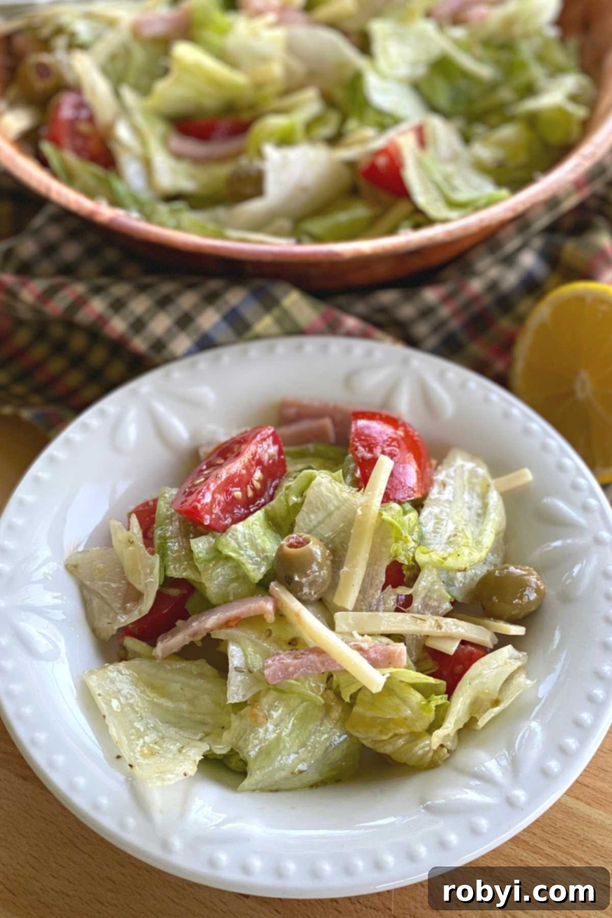 Side serving of Copycat 1905 salad on a small plate with larger bowl behind.