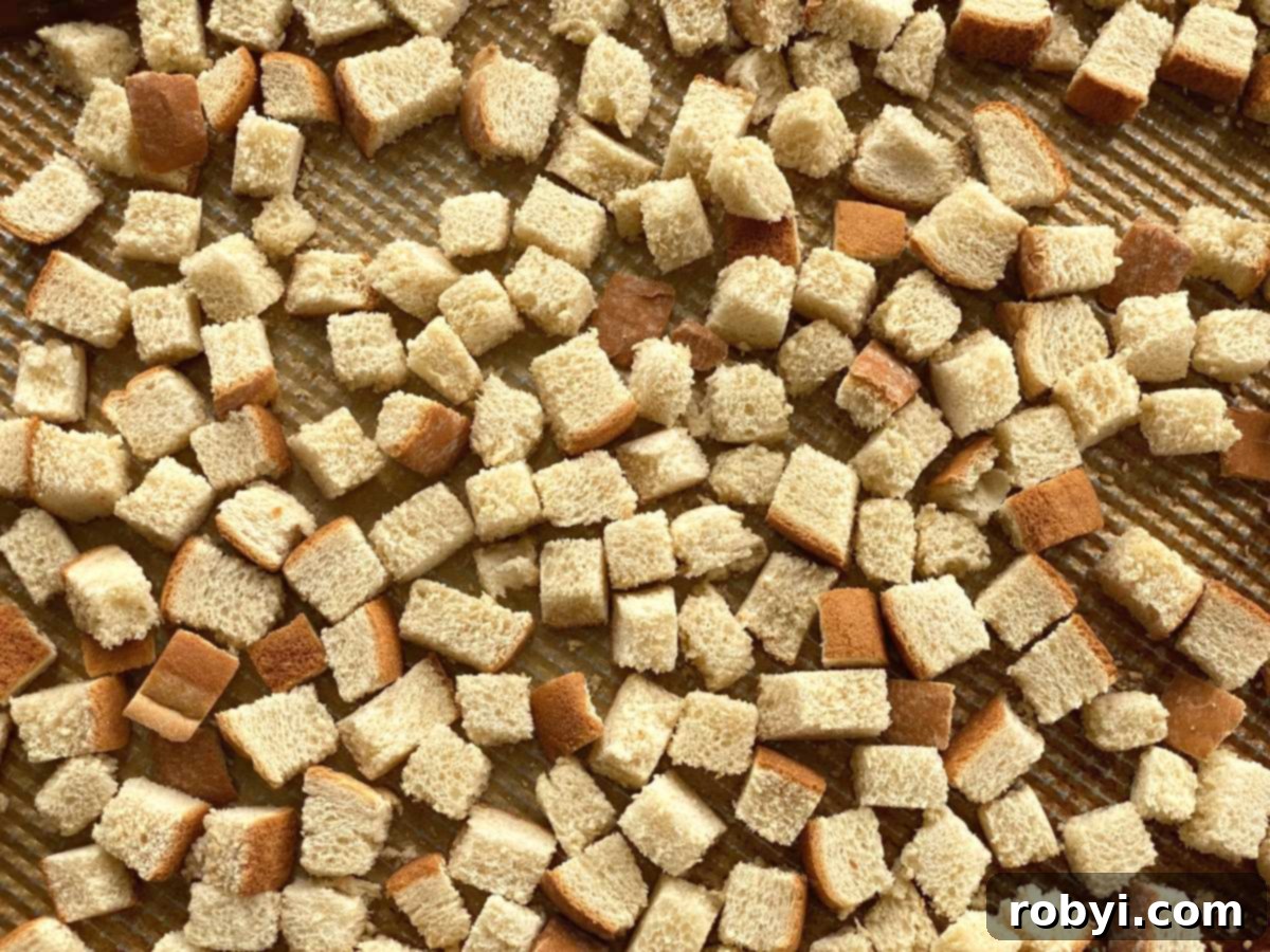 Prep-Ahead Oven Stuffing 4 Freshly cut bread cubes spread evenly on a baking sheet, ready for oven drying.