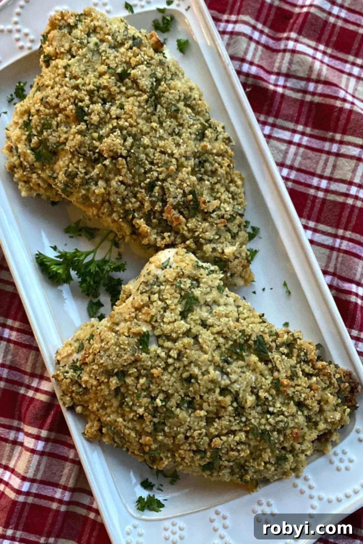 A full turkey tenderloin, beautifully crusted with herbs and Parmesan, presented on an elegant serving platter.