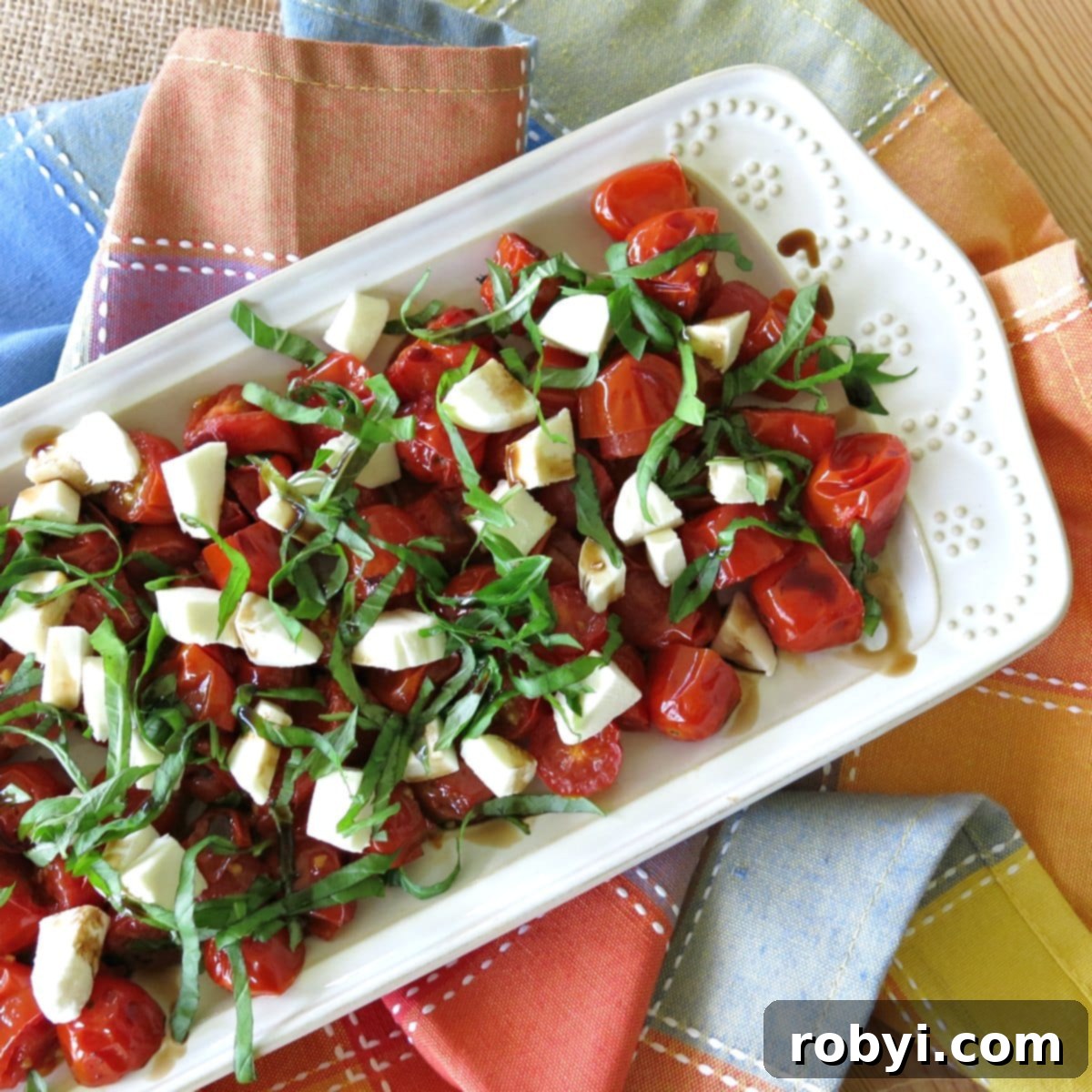 Roasted Grape Tomato Caprese Salad served on a rectangular white plate.