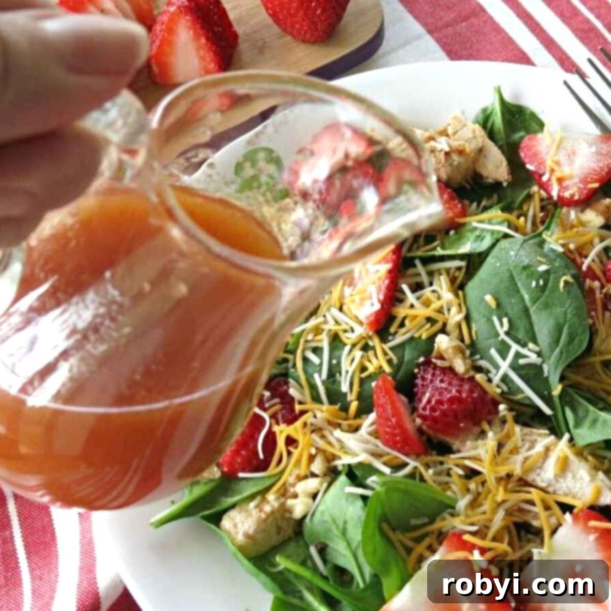 Red wine vinegar dressing being poured over a fresh, crisp green salad.