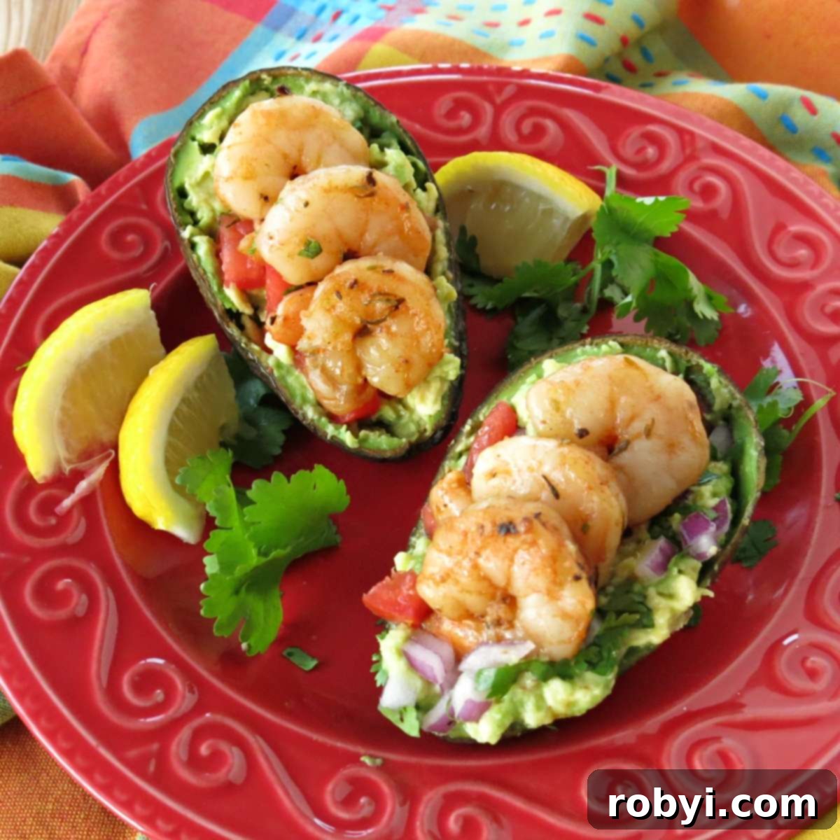 Two avocado halves filled with fresh guacamole and topped with three succulent shrimp each, presented as delightful guacamole boats.