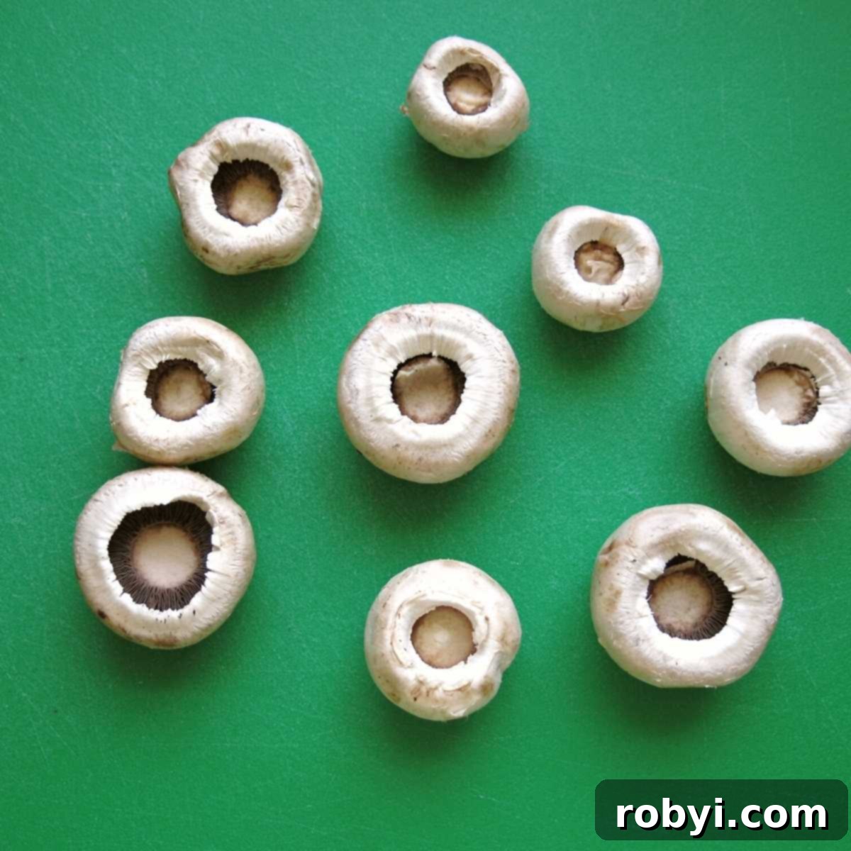 Mushroom caps with stems carefully removed, ready for filling.