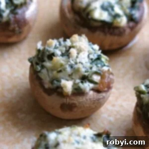 A close-up image of a serving platter filled with golden-brown, easy stuffed mushrooms with cream cheese, garnished with fresh herbs.