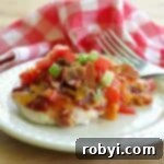 Copycat Chili's Monterey Chicken on a plate with a red checkered napkin and fork behind it.