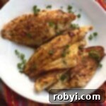 Three Cajun catfish filets on a plate.