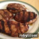 4 pork chops with molasses marinade on a plate.