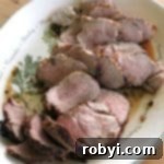Sliced pork tenderloin in red wine marinade on a platter