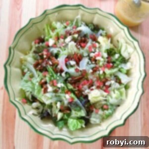 A large bowl filled with a fresh Summer Fennel Salad, featuring beautifully shaved fennel, creamy feta cheese, crunchy candied pecans, and sweet watermelon cubes.