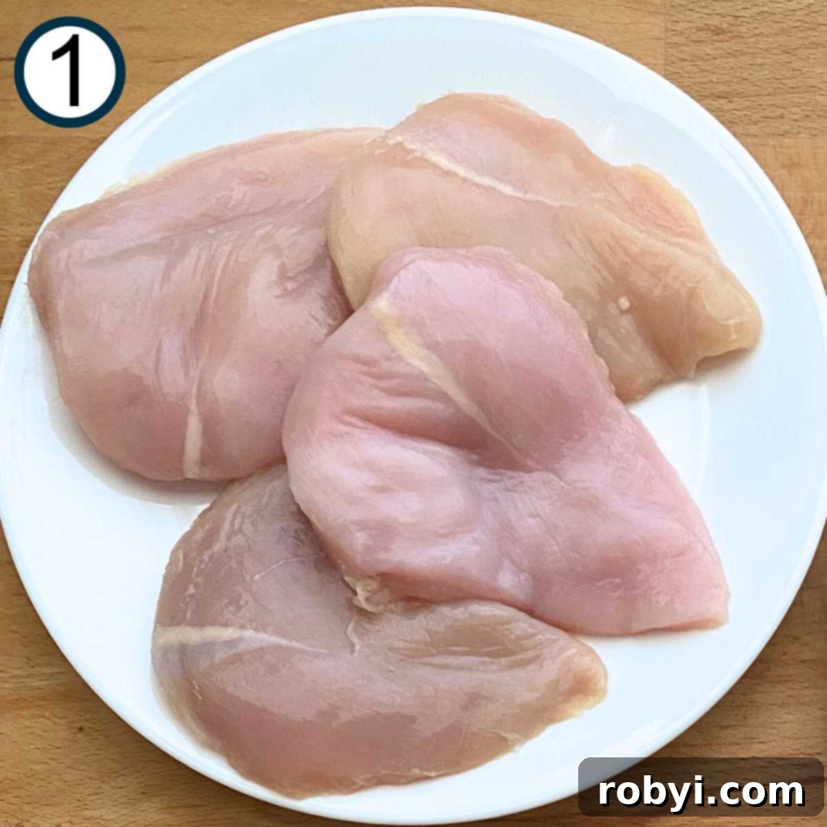 Crispy Ritz Cracker Chicken Perfection 4 Four boneless, skinless, chicken breasts on a plate.