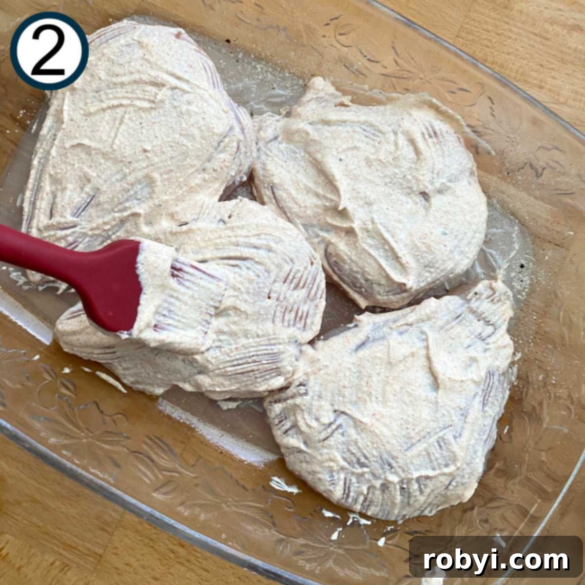 Crispy Ritz Cracker Chicken Perfection 5 Creamy sour cream mixture being brushed on top of the chicken with a silicone brush.