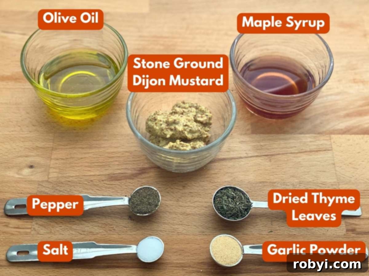 Olive oil, stone ground mustard, maple syrup, pepper, salt, dried thyme leaves, and garlic powder in glass cups or measuring spoons with a text overlay with the name of each ingredient.
