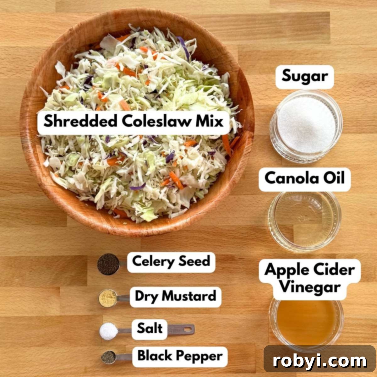 Ingredients in measuring cups and bowls to make the recipe: shredded cabbage and carrots, sugar, canola oil, apple cider vinegar, celery seed, dry mustard, salt, and black pepper.