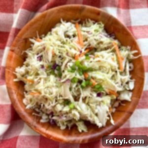 Southern coleslaw with vinegar dressing in a brown bowl on top of a red checkered cloth.