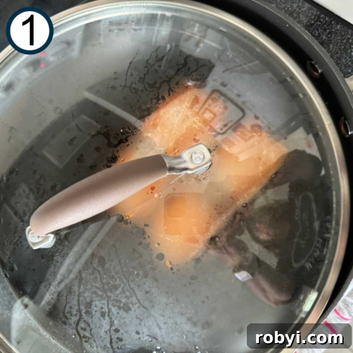 Salmon fillets cooking in a large non-stick skillet.