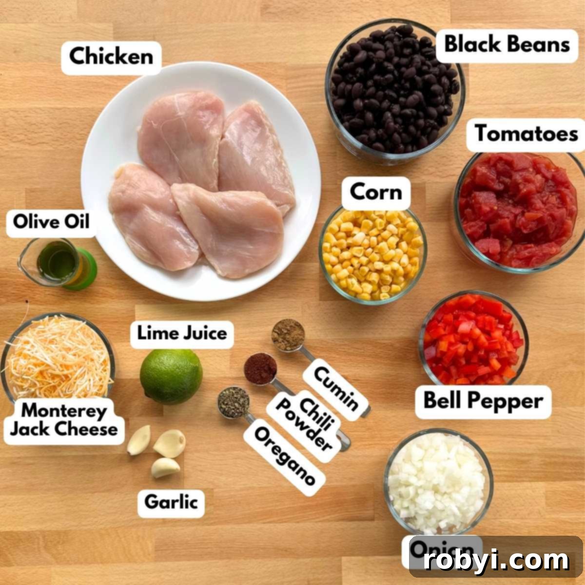Chuckwagon Chicken Dinner 3 Labeled ingredients to make cowboy chicken recipe: chicken, black beans, corn, tomatoes, bell pepper, onion, shredded cheese, cumin, chili powder, oregano, lime, garlic, lime juice.
