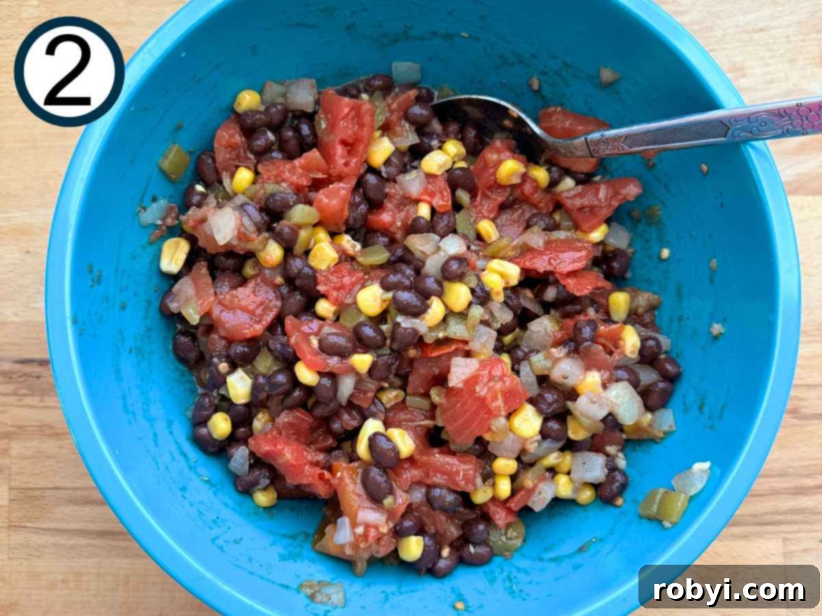 Chuckwagon Chicken Dinner 5 Black beans, corn, tomatoes, peppers, garlic, olive oil, lime, juice, and spices mixed together into a turquoise bowl, forming the salsa.