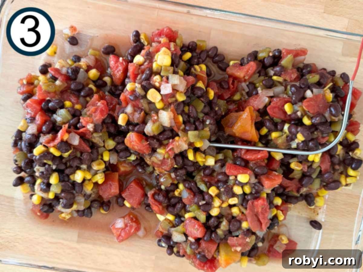 Chuckwagon Chicken Dinner 6 Black bean corn salsa layered over chicken in a casserole dish with a meat thermometer sticking out, ready for baking.