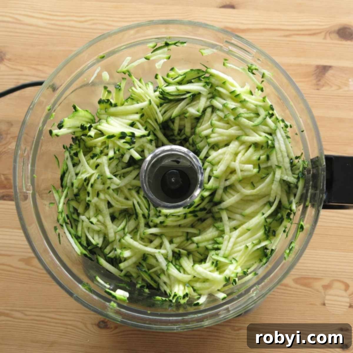 Decadent Zucchini Chocolate Brownies 3 Freshly grated zucchini sitting in the base of a food processor, ready to be incorporated into the brownie batter.