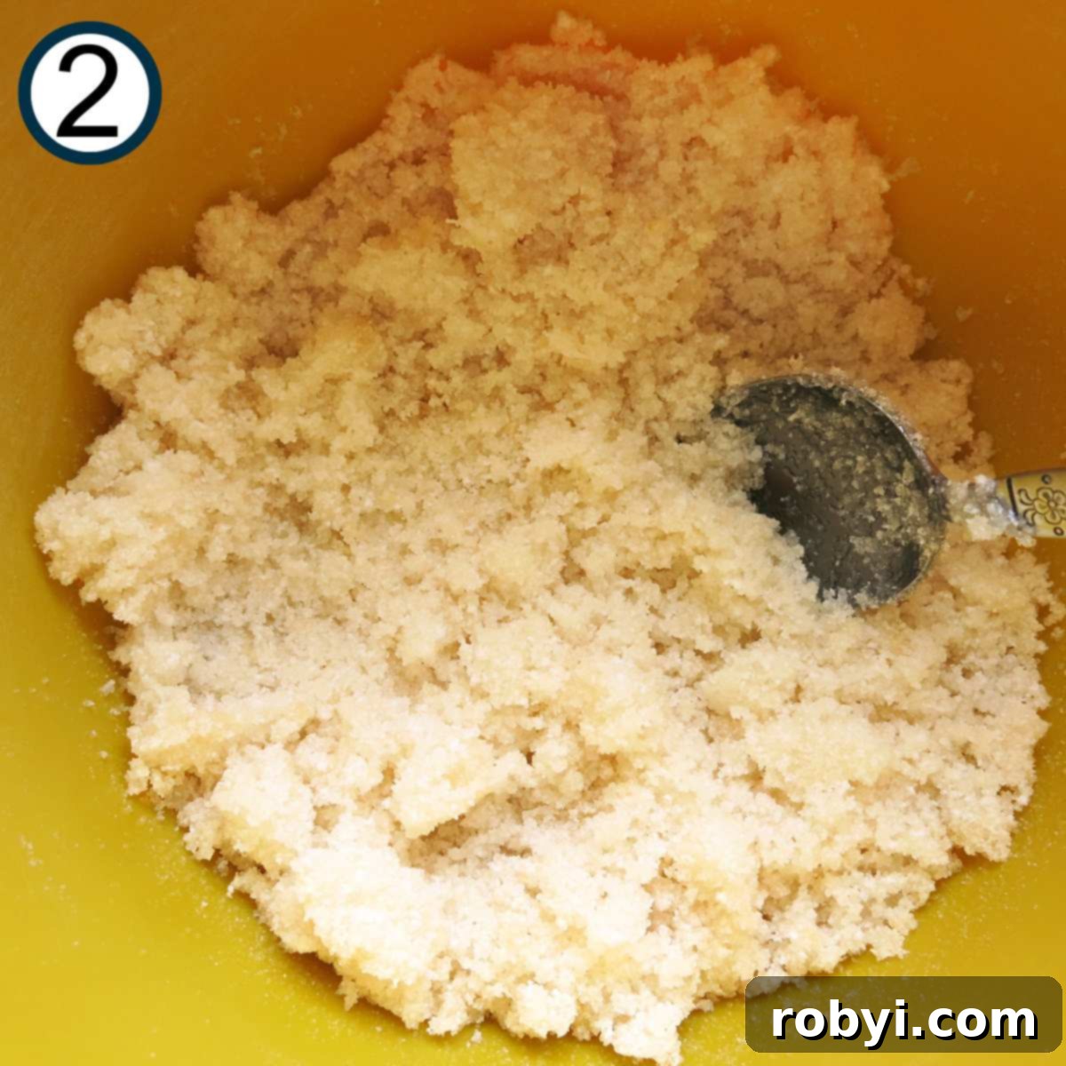 Decadent Zucchini Chocolate Brownies 5 A mixing bowl contains a crumbly mixture of sugar, oil, and vanilla extract, ready to be combined with dry ingredients.