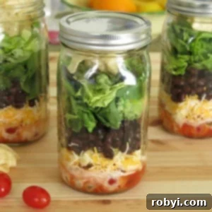 Build the Perfect Layered Taco Salad Jar: Prep & Packing Hacks 6 Close-up of a single taco salad in a jar, showcasing the detailed layering of ingredients.