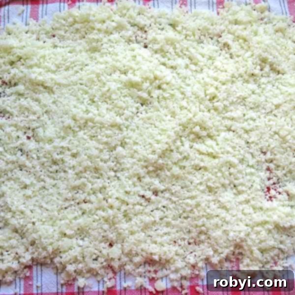 Healthy Cauliflower Pizza: Bites or Crispy Crust 4 Cooked cauliflower rice for cauliflower pizza dough spread on a dish towel to cool down.